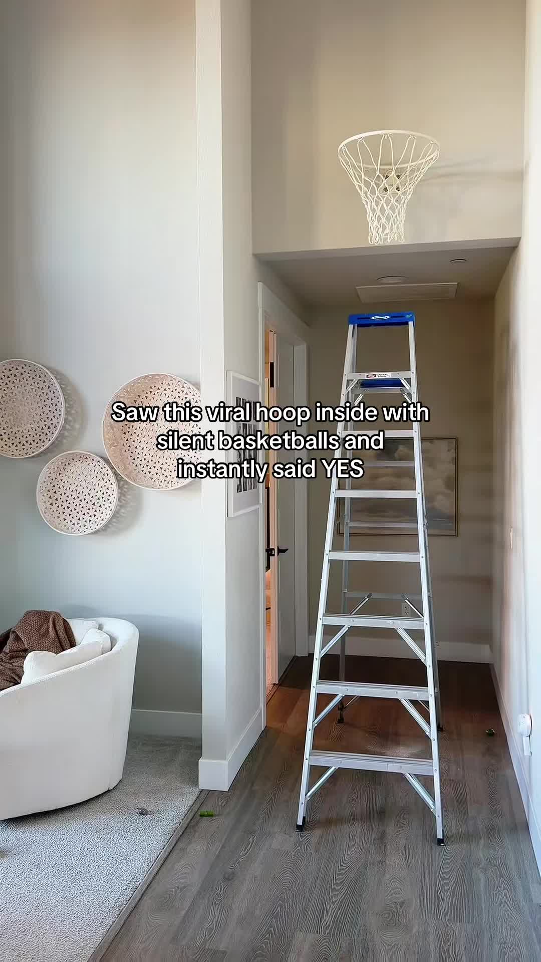 indoor basketball hoop mounted in hallway nook with ladder during installation