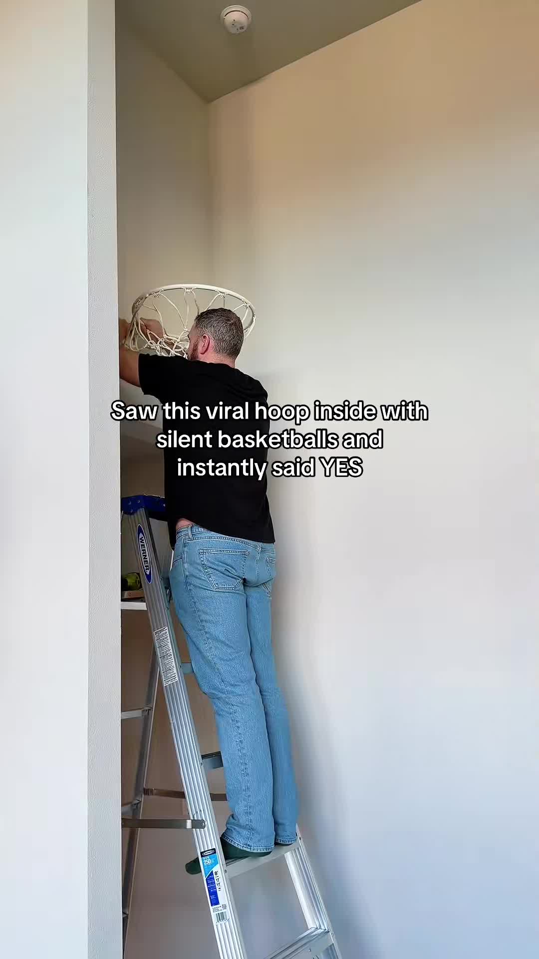 dad installing basketball hoop rim on wall for indoor silent basketball