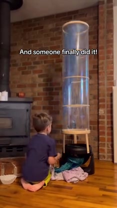 child watching DIY wind tunnel with scarves floating embroidery hoops and clear tube