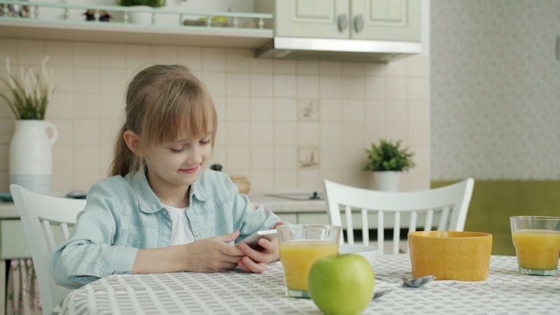 Child sitting at table with food in front of them, PDA food refusal mealtime